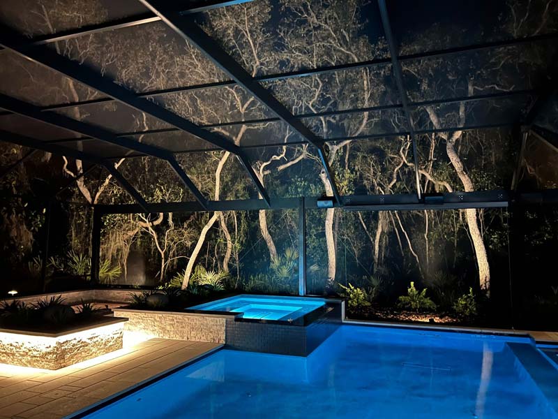 A pool beneath a glass roof, surrounded by trees in Jacksonville, FL.