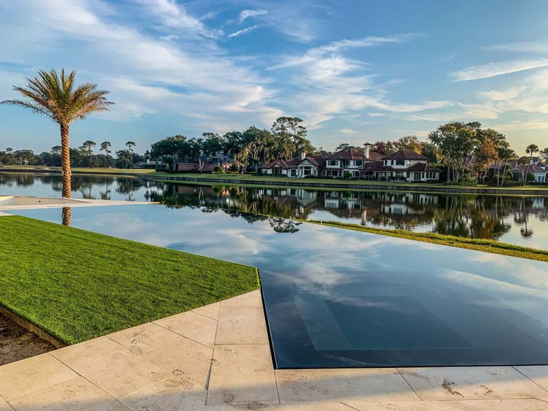 Poolside view with lush lawn and palm trees in Jacksonville, FL.