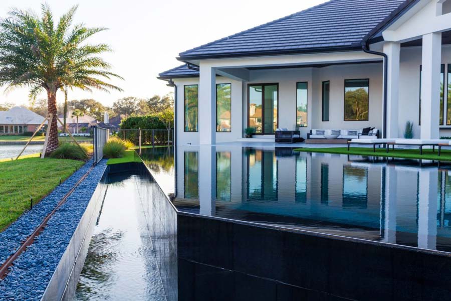 Modern home  featuring a pool and expansive lawn in Jacksonville, FL,